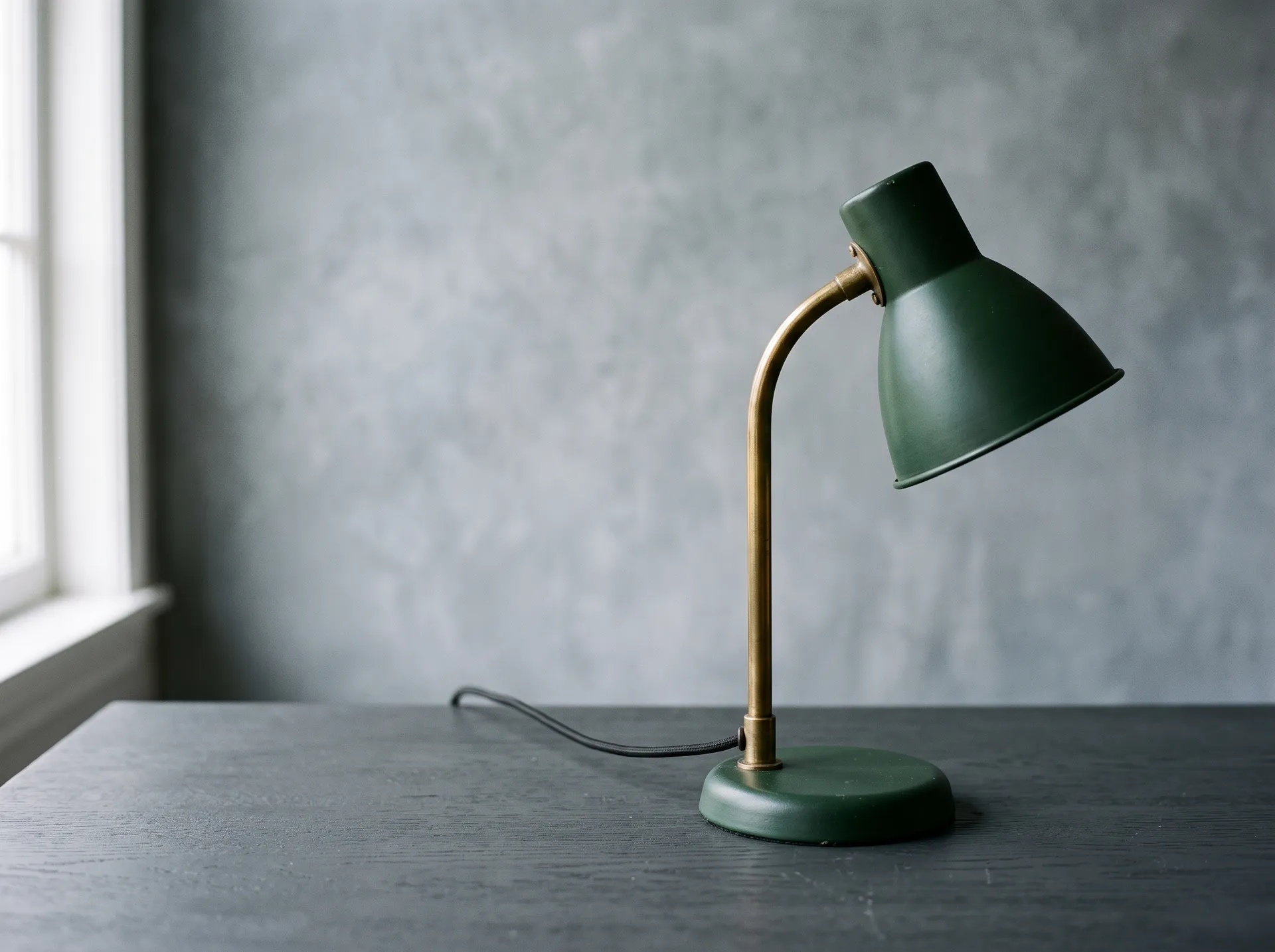 Unbranded green metal table lamp on a dark studio surface