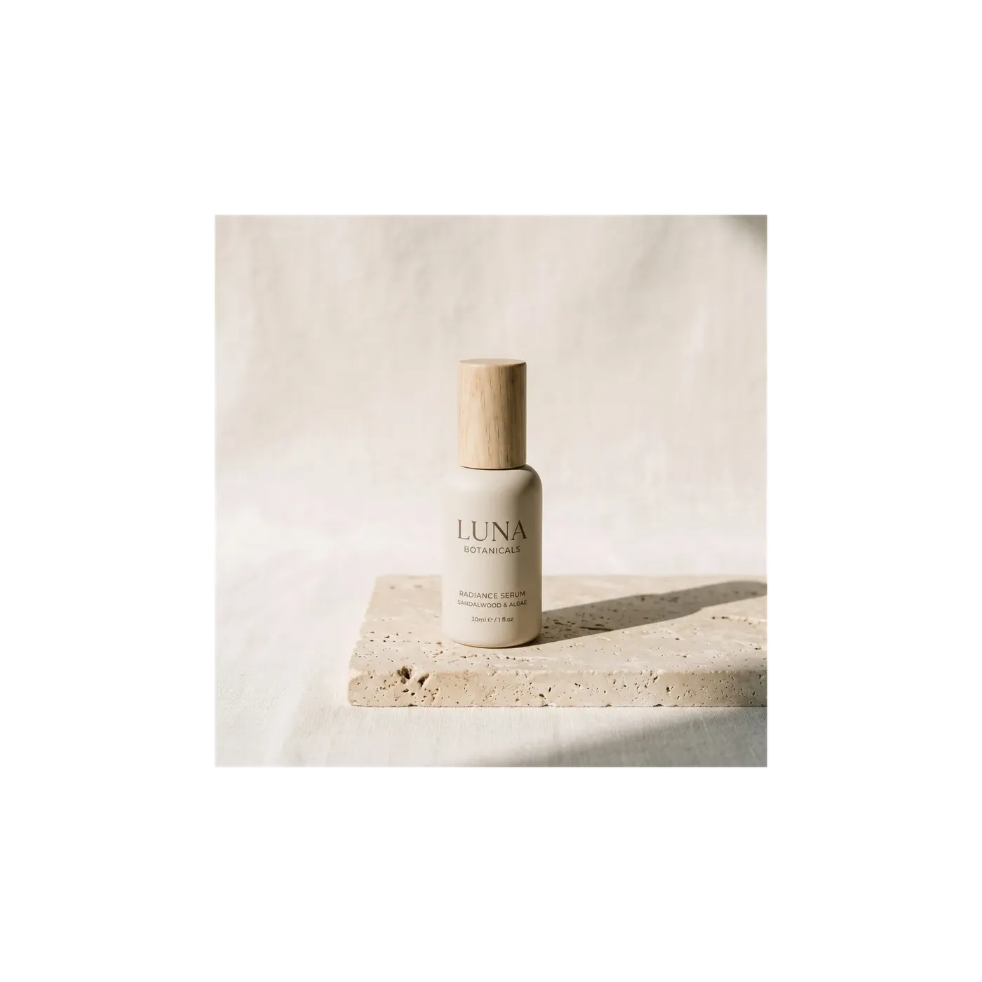Square 1:1 product photograph of a cream ceramic serum bottle on a travertine slab, shown at true scale as the before frame of a resize comparison, generated on getimg.ai.