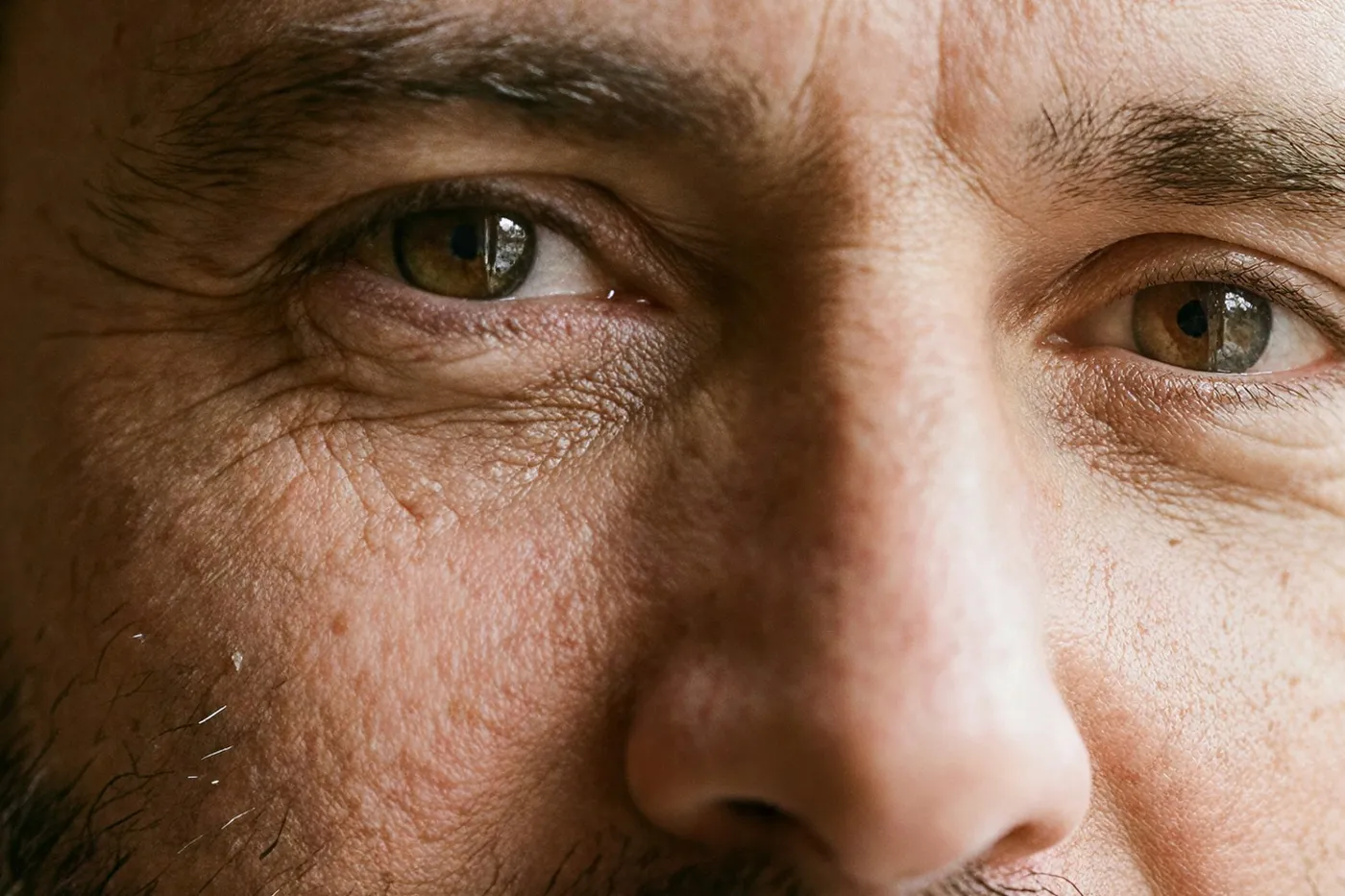 Close crop of an upscaled portrait showing eyelashes, pores, laugh lines and beard hairs to review