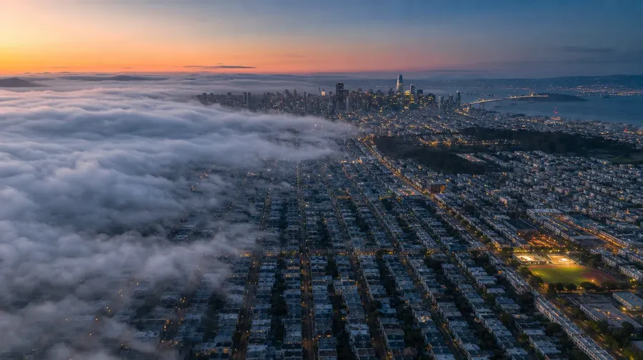 Top-down San Francisco grid at blue hour with rolling fog — AI-generated aerial image.