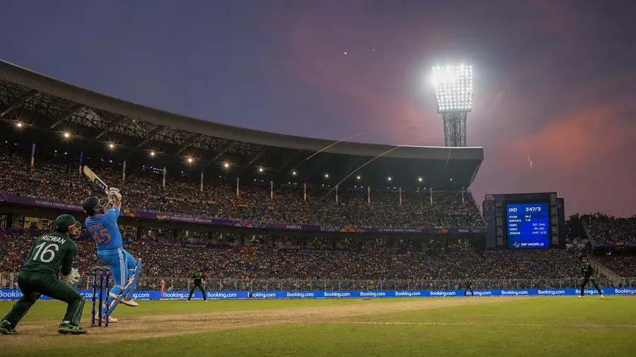 Eden Gardens India-Pakistan ODI six toward long-on at dusk — AI-generated cricket stock image.
