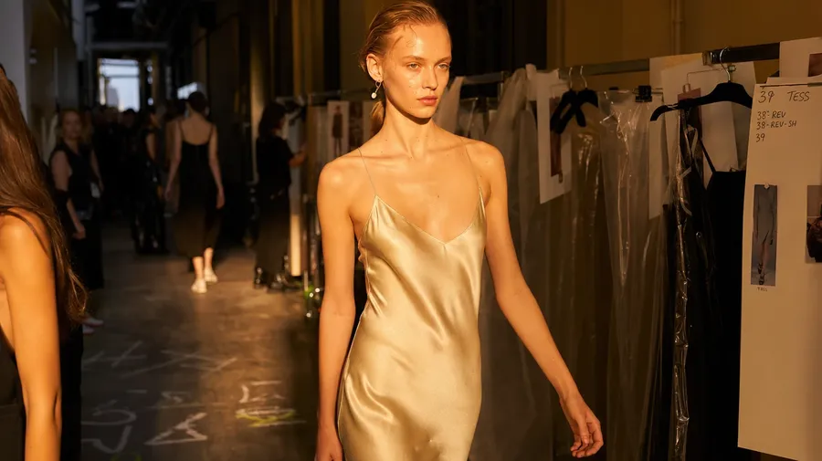 Model in silk slip dress backstage at a Milan runway show — AI-generated fashion stock image.