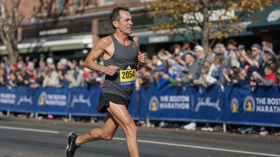 Master's marathoner at mile 23 of the Boston Marathon in mid-afternoon, AI-generated running images stock.