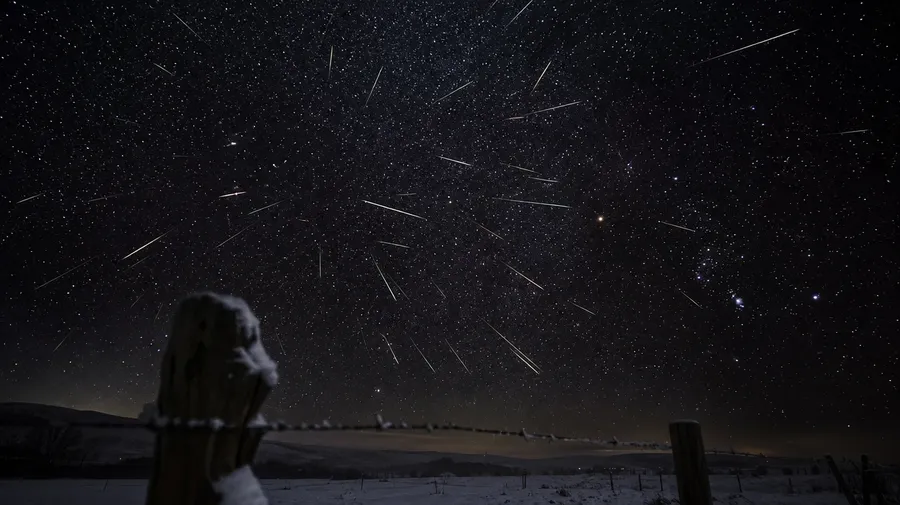 AI-generated star image: Geminid meteor shower streaks across a winter Orion sky over a snowy fence.