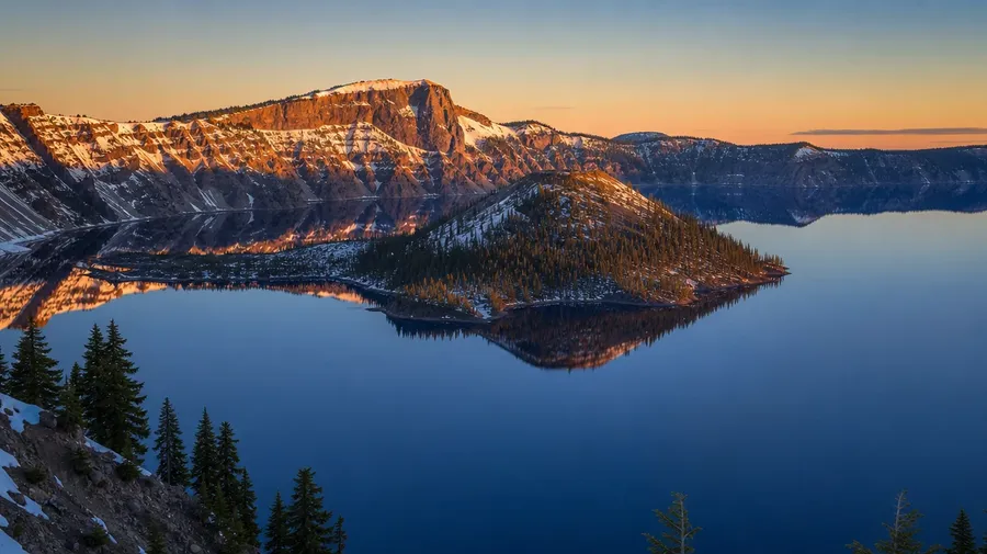 AI-generated volcano picture: Crater Lake caldera with cobalt-blue water and Wizard Island at golden hour.