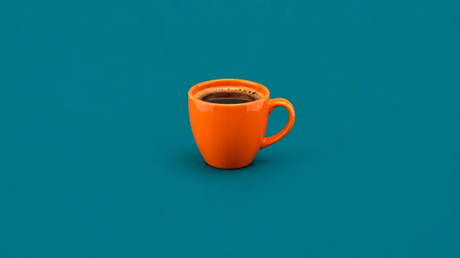 A single orange coffee cup centred on a flat teal surface with empty space around it.