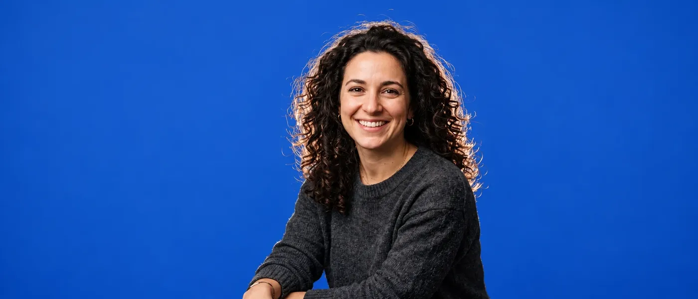 Same source portrait on a flat cobalt blue backdrop, one of eight backgrounds generated on getimg.ai