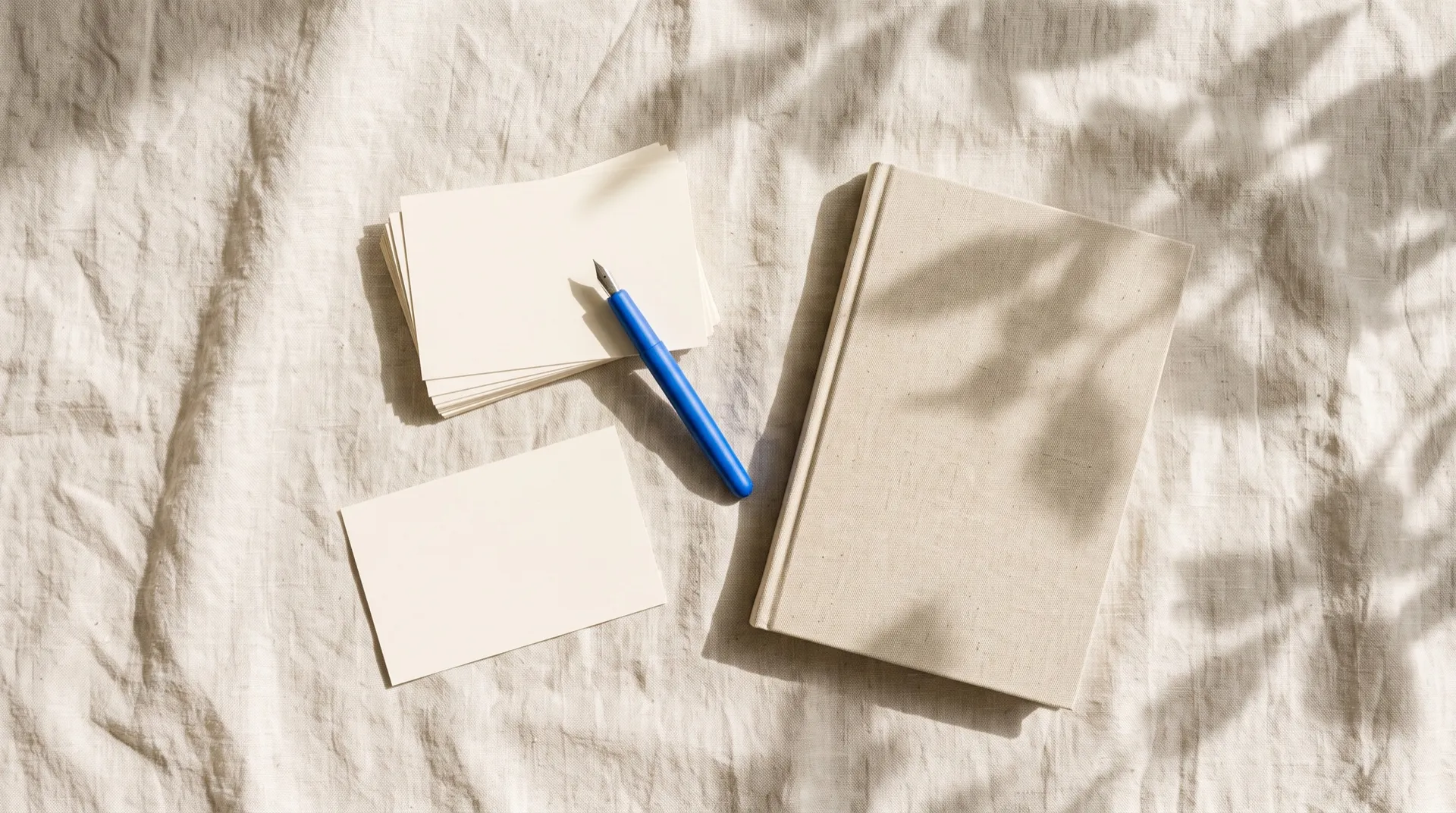 Blank index cards, a linen notebook and a blue fountain pen on linen in morning light, featured image for a list of AI video editing prompts, created on getimg.ai