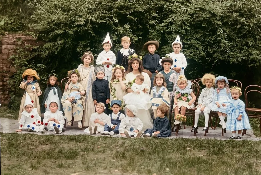The same group photograph of costumed children after AI restoration and colorization on getimg.ai, showing green foliage, natural skin tones, and varied clothing colours.