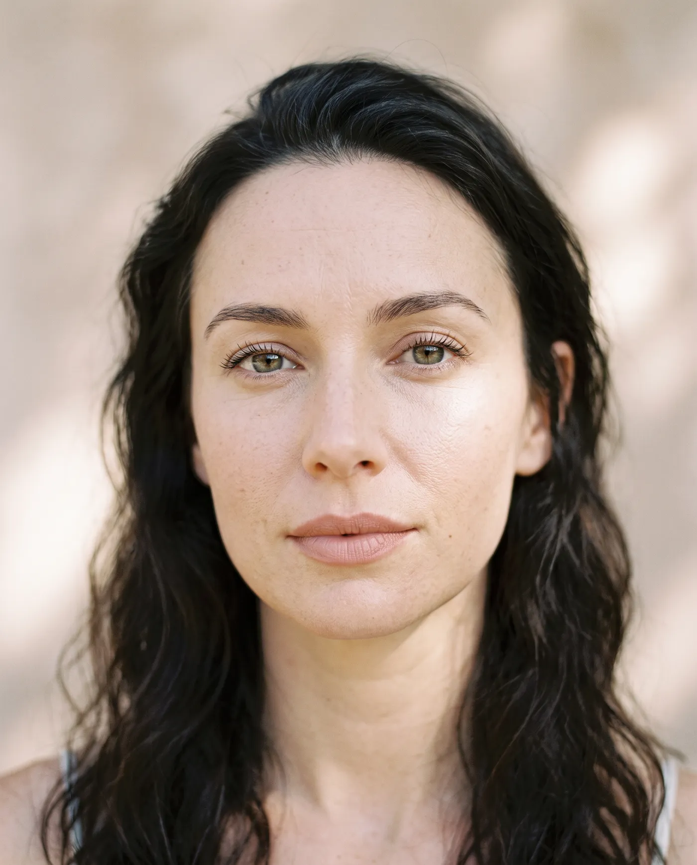 portrait photo of a woman with long dark hair and a neutral expression, used as a first frame for getimg.ai's image to video feature