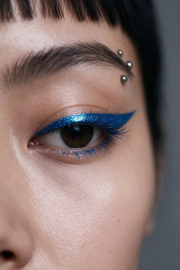 Macro close-up of the character's eye showing shimmering cobalt-blue winged eyeliner and a silver eyebrow piercing, a signature-detail shot generated with getimg.ai.