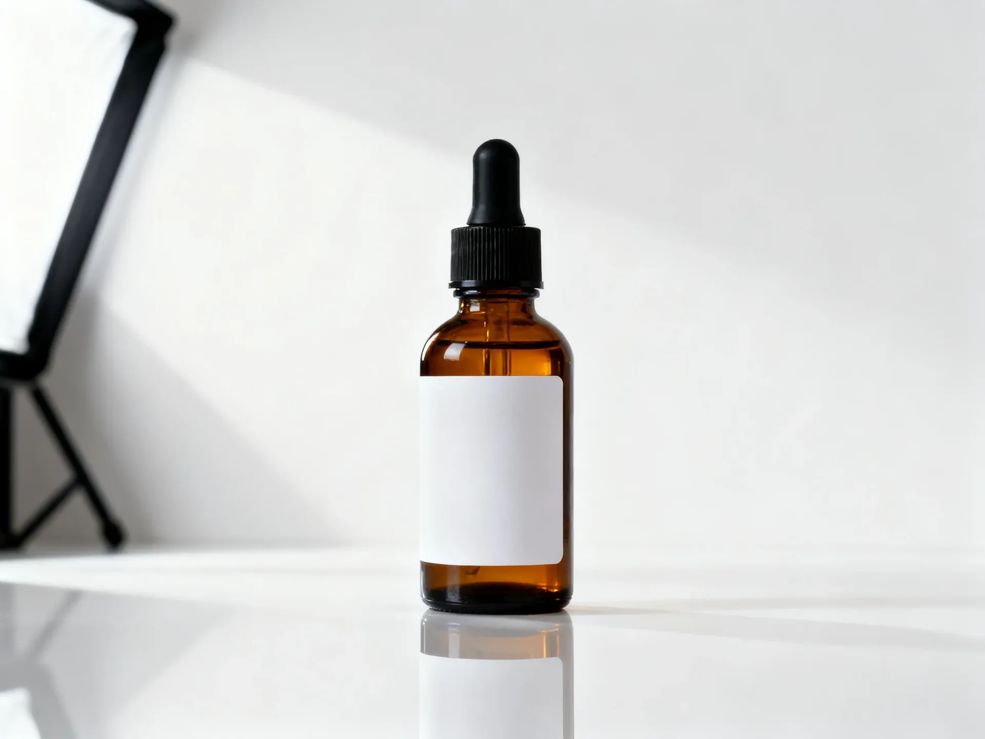 Amber glass serum bottle with a black dropper cap and a plain white label, photographed on a seamless white studio sweep. Source packshot for getimg.ai's background-replacement editing test, generated with getimg.ai.