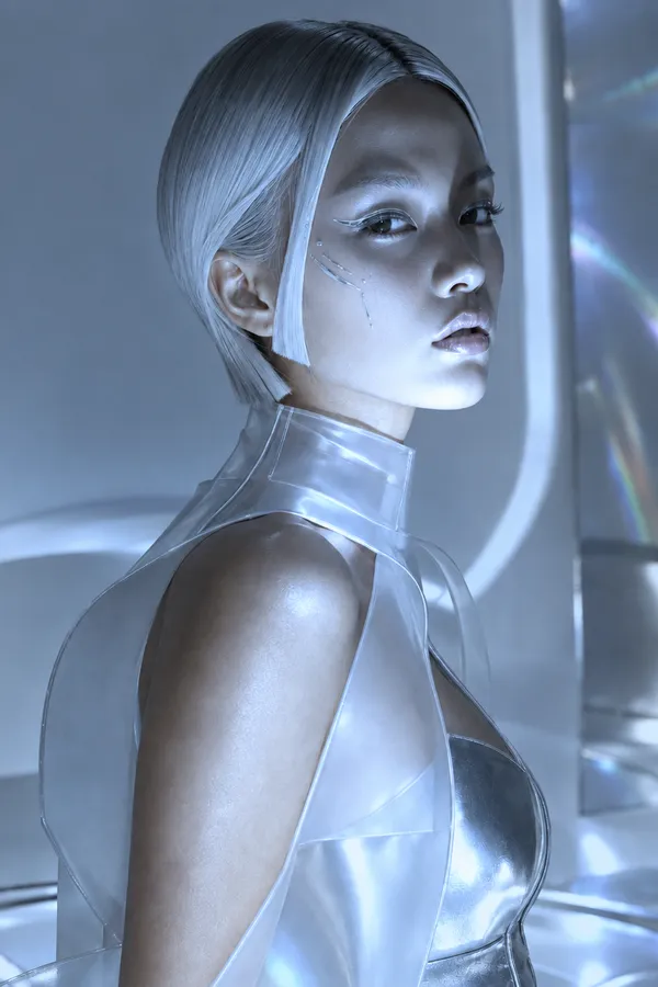 AI relighting example from the Relight Action on getimg.ai: the same futuristic portrait relit with a bright, cool blue-white key light that gives her skin and clear silver outfit a high-key silvery sheen.
