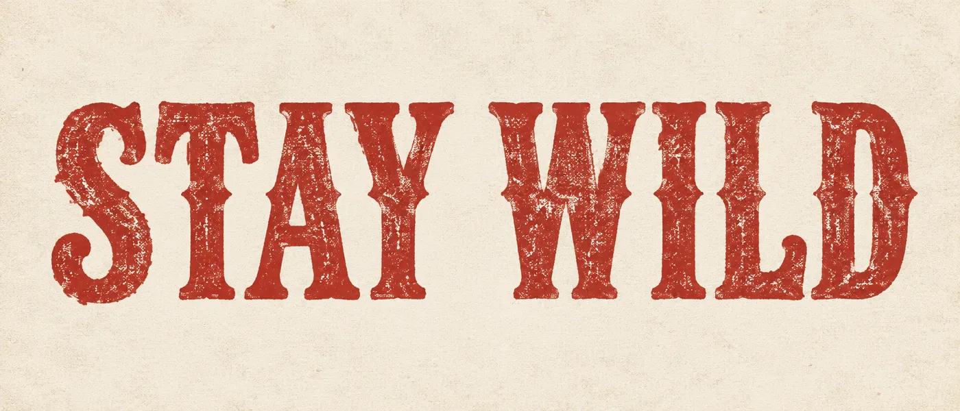 Ultrawide word art reading STAY WILD in distressed red western serif on cream paper